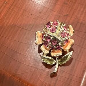 Vintage 1960s pin with pink rhinestone and enamel accents.